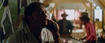 Movie still from “Road Games” (1981), directed by Richard Franklin – A man talking on a phone while wearing a cowboy hat; Close Up shot, Low angle