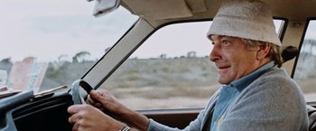 Movie still from “Road Games” (1981), directed by Richard Franklin – A man sitting in the driver's seat of a car; Close Up shot, Low angle
