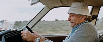 Movie still from “Road Games” (1981), directed by Richard Franklin – A man driving a car in the middle of a field; Close Up shot, Low angle