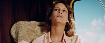Movie still from “Road Games” (1981), directed by Richard Franklin – A woman sitting on top of a couch looking up; Close Up shot, Low angle