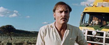 Movie still from “Road Games” (1981), directed by Richard Franklin – A person with a mustache wearing a white shirt; Close Up shot, Low angle
