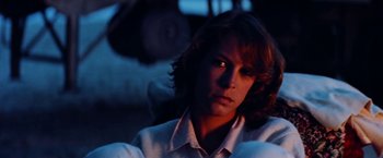 Movie still from “Road Games” (1981), directed by Richard Franklin – A man with long red hair sitting in the dark; Close Up shot, Low angle