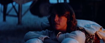 Movie still from “Road Games” (1981), directed by Richard Franklin – A person sitting in a chair in the dark; Close Up shot, Low angle