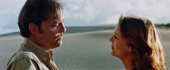 Movie still from “Road Games” (1981), directed by Richard Franklin – A man and a woman face to face on a beach; Close Up shot, Low angle