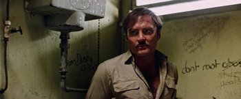 Movie still from “Road Games” (1981), directed by Richard Franklin – A person wearing a shirt and a mustache; Close Up shot, Low angle