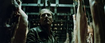 Movie still from “Road Games” (1981), directed by Richard Franklin – A man in a leather jacket looking up at the ceiling; Close Up shot, Low angle