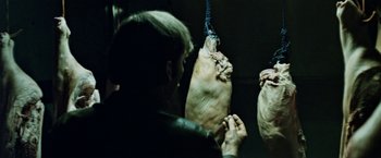 Movie still from “Road Games” (1981), directed by Richard Franklin – A person is holding a pig on a rope; Close Up shot, Low angle