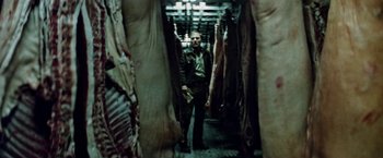 Movie still from “Road Games” (1981), directed by Richard Franklin – A man walking through a room filled with meat; Medium shot, Low angle