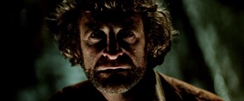 Movie still from “Road Games” (1981), directed by Richard Franklin – A person with a beard and curly hair; Extreme Close Up shot, Low angle