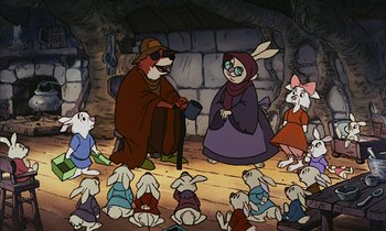 Movie still from “Robin Hood” (1973), directed by David Hand – A group of people sitting in front of a fireplace; Wide shot, High angle