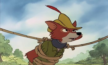 Movie still from “Robin Hood” (1973), directed by David Hand – A cartoon picture of a fox wearing a hat and rope; Close Up shot, High angle