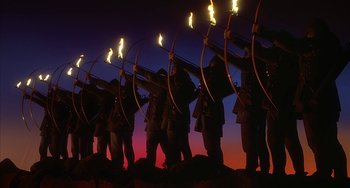 Movie still from “Robin Hood: Men in Tights” (1993), directed by Mel Brooks – A group of men holding torches and bows in front of a purple sky; Wide shot, Low angle