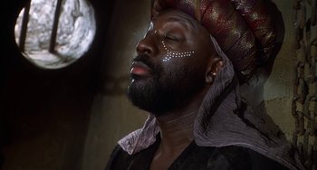 Movie still from “Robin Hood: Men in Tights” (1993), directed by Mel Brooks – A man with a beard and a turban on his head; Close Up shot, Low angle
