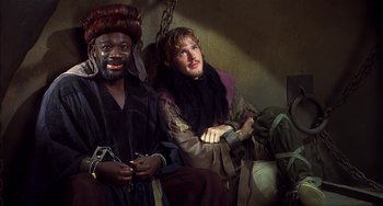 Movie still from “Robin Hood: Men in Tights” (1993), directed by Mel Brooks – Two men sitting next to each other on a bench; Medium shot, High angle