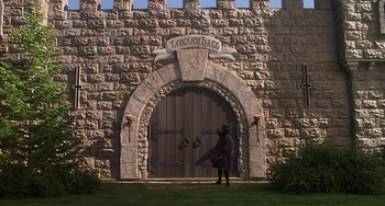 Movie still from “Robin Hood: Men in Tights” (1993), directed by Mel Brooks – A person standing in front of a castle door; Extreme Wide shot, Low angle