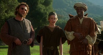 Movie still from “Robin Hood: Men in Tights” (1993), directed by Mel Brooks – A group of people standing next to each other on top of a grass covered field; Medium shot, Low angle