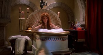 Movie still from “Robin Hood: Men in Tights” (1993), directed by Mel Brooks – A woman with a red wig sitting in a tub of water; Medium shot, High angle