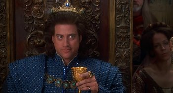 Movie still from “Robin Hood: Men in Tights” (1993), directed by Mel Brooks – A man in a crown holding a gold cup; Close Up shot, Low angle