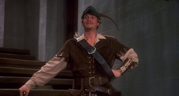 Movie still from “Robin Hood: Men in Tights” (1993), directed by Mel Brooks – A man dressed as a robin hood in a costume; Medium shot, Low angle