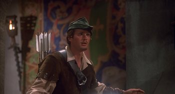 Movie still from “Robin Hood: Men in Tights” (1993), directed by Mel Brooks – A man wearing a hat and holding a bow and arrow; Close Up shot, Over the shoulder angle