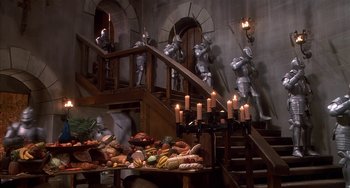 Movie still from “Robin Hood: Men in Tights” (1993), directed by Mel Brooks – A room with a staircase and a bunch of food on the stairs; Wide shot, High angle
