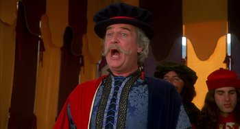 Movie still from “Robin Hood: Men in Tights” (1993), directed by Mel Brooks – A man with a beard and mustache wearing a hat; Close Up shot, Low angle