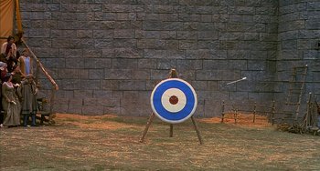 Movie still from “Robin Hood: Men in Tights” (1993), directed by Mel Brooks – An archery target is set up in the grass; Wide shot, Overhead angle