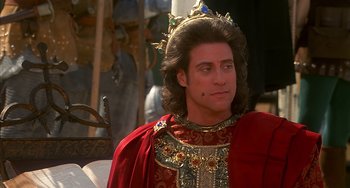 Movie still from “Robin Hood: Men in Tights” (1993), directed by Mel Brooks – A person wearing a crown and a red robe; Close Up shot, Over the shoulder angle