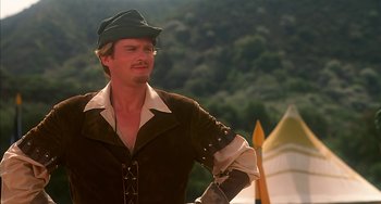 Movie still from “Robin Hood: Men in Tights” (1993), directed by Mel Brooks – A man in a brown jacket and a green hat; Medium shot, Low angle