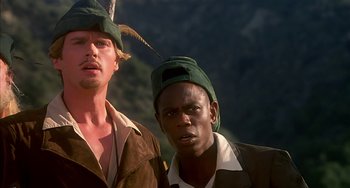 Movie still from “Robin Hood: Men in Tights” (1993), directed by Mel Brooks – Two men wearing hats and one has a bird on his head; Close Up shot, Low angle