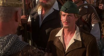 Movie still from “Robin Hood: Men in Tights” (1993), directed by Mel Brooks – A man wearing a green hat and a brown jacket; Close Up shot, High angle