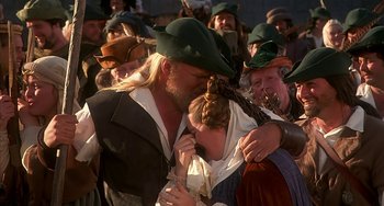 Movie still from “Robin Hood: Men in Tights” (1993), directed by Mel Brooks – A man and a woman kissing in front of a crowd of onlookers; Close Up shot, Over the shoulder angle