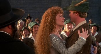 Movie still from “Robin Hood: Men in Tights” (1993), directed by Mel Brooks – A man and a woman in medieval garb in front of a crowd; Medium shot, Over the shoulder angle