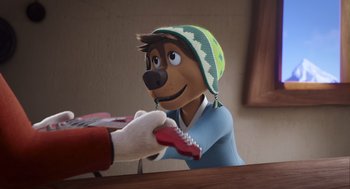 Movie still from “Rock Dog 2: Rock Around the Park” (2021), directed by Mark Baldo – A person is handing something to a statue of a dog; Close Up shot, Over the shoulder angle