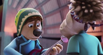 Movie still from “Rock Dog 2: Rock Around the Park” (2021), directed by Mark Baldo – A cartoon character playing a guitar while another cartoon character looks on; Close Up shot, Over the shoulder angle