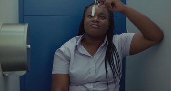 Movie still from “Rocks” (2019), directed by Sarah Gavron – A woman holding a tooth brush up to her face; Extreme Close Up shot, Low angle