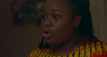 Movie still from “Rocks” (2019), directed by Sarah Gavron – A young man with dreadlocks is making a funny face for the camera; Close Up shot, Low angle