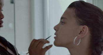 Movie still from “Rocks” (2019), directed by Sarah Gavron – A woman is putting makeup on her face; Close Up shot, Over the shoulder angle