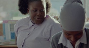 Movie still from “Rocks” (2019), directed by Sarah Gavron – A woman sitting next to another woman on a couch; Close Up shot, Over the shoulder angle