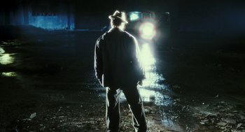 Movie still from “Rocky Balboa” (2006), directed by Sylvester Stallone – A man standing in the middle of a road at night; Wide shot, Over the shoulder angle