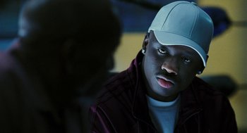 Movie still from “Rocky Balboa” (2006), directed by Sylvester Stallone – A man wearing a white hat and a maroon jacket; Close Up shot, Over the shoulder angle