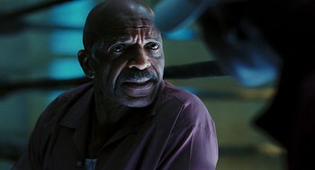 Movie still from “Rocky Balboa” (2006), directed by Sylvester Stallone – An older man in a purple shirt is looking at the camera; Close Up shot, Over the shoulder angle