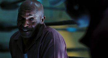 Movie still from “Rocky Balboa” (2006), directed by Sylvester Stallone – A man with a bald head is sitting in front of a wall; Close Up shot, Low angle