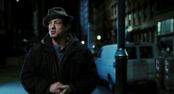 Movie still from “Rocky Balboa” (2006), directed by Sylvester Stallone – A man wearing a hat standing next to a pole; Close Up shot, Over the shoulder angle