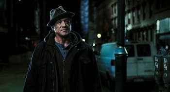 Movie still from “Rocky Balboa” (2006), directed by Sylvester Stallone – A man wearing a hat standing next to a street light; Medium shot, Over the shoulder angle