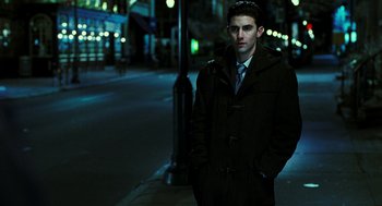 Movie still from “Rocky Balboa” (2006), directed by Sylvester Stallone – A man standing on the side of the street at night; Medium shot, Low angle