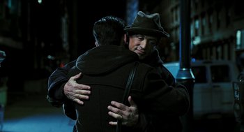 Movie still from “Rocky Balboa” (2006), directed by Sylvester Stallone – Two men hugging each other in the dark; Medium shot, Over the shoulder angle
