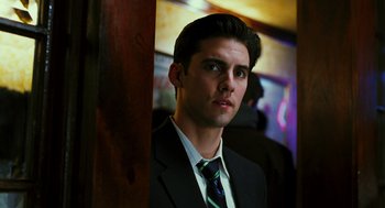 Movie still from “Rocky Balboa” (2006), directed by Sylvester Stallone – A man in a suit and tie standing next to a wooden pole; Close Up shot, Low angle