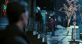 Movie still from “Rocky Balboa” (2006), directed by Sylvester Stallone – A woman walking down the sidewalk at night; Wide shot, Over the shoulder angle