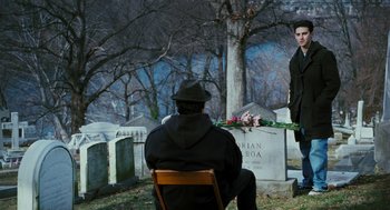 Movie still from “Rocky Balboa” (2006), directed by Sylvester Stallone – A man sitting in front of a headstone in a cemetary; Wide shot, Over the shoulder angle